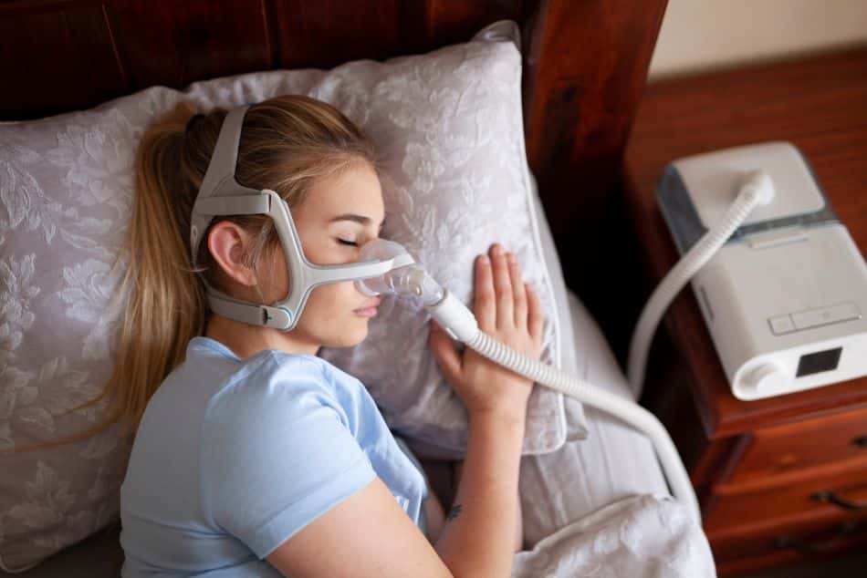 A woman sleeping while using a CPAP machine